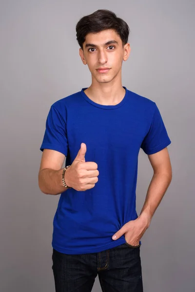 Молодой красивый персидский подросток, показывающий большой палец — стоковое фото