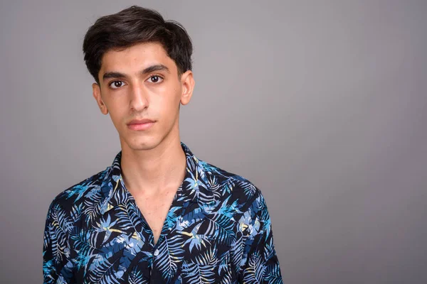 Young handsome Persian teenage boy wearing Hawaiian shirt agains — Stock Photo, Image