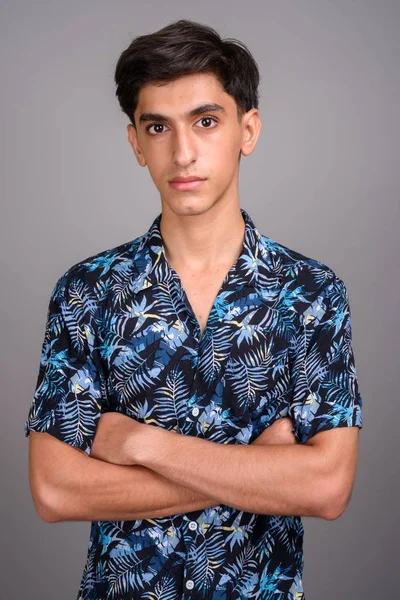 Young handsome Persian teenage boy wearing Hawaiian shirt agains — Stock Photo, Image