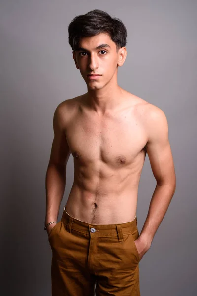 Krásný perský dospívající mladík shirtless proti šedé pozadí — Stock fotografie