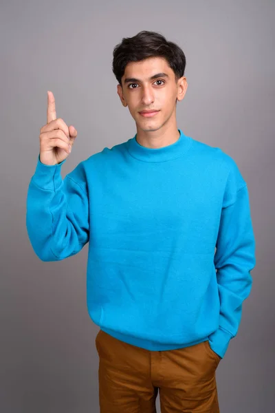 Ung vacker Persiska tonårspojke pekande finger upp — Stockfoto