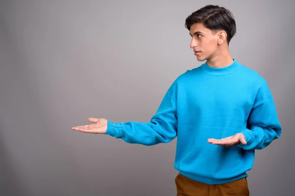 Jovem bonito persa adolescente menino mostrando copyspace — Fotografia de Stock