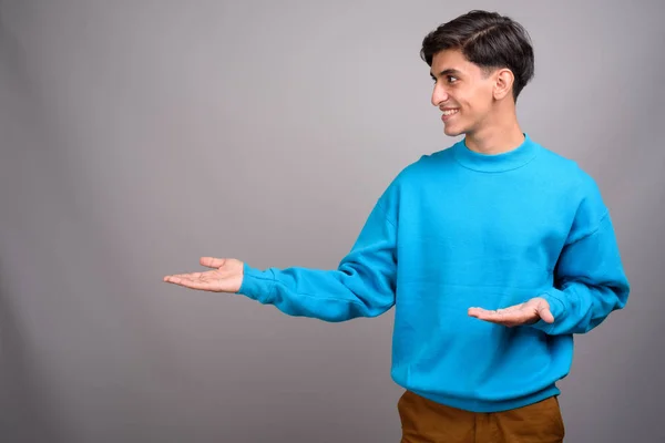 Jovem bonito persa adolescente menino mostrando copyspace — Fotografia de Stock