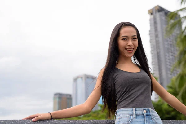 Jonge mooie Aziatische vrouw glimlachend en ontspannen in het park — Stockfoto