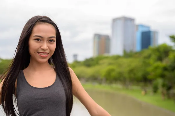 Heureuse jeune belle femme asiatique souriante et relaxante au parc — Photo