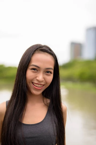 Jovem feliz bela mulher asiática sorrindo para o parque — Fotografia de Stock