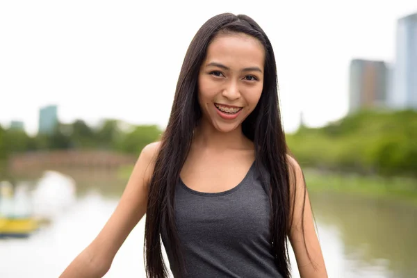 Feliz joven hermosa mujer asiática sonriendo en el parque —  Fotos de Stock