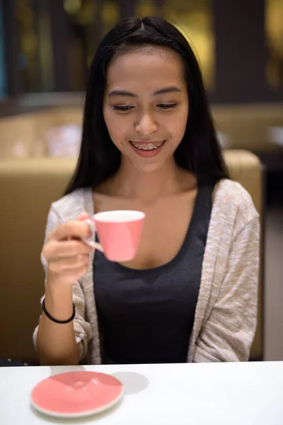 Glad ung Vacker asiatisk kvinna avkopplande inuti coffee shop — Stockfoto