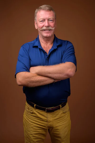 Sênior feliz sorrindo com os braços cruzados — Fotografia de Stock