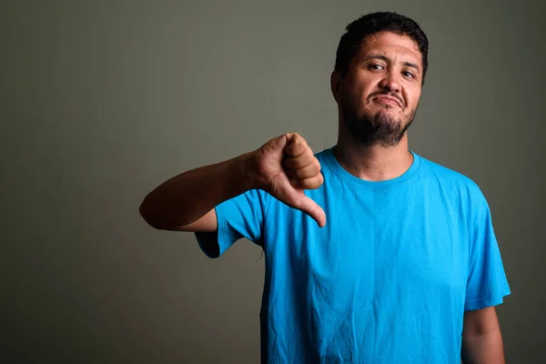 Hombre persa barbudo con camisa azul contra fondo de color —  Fotos de Stock