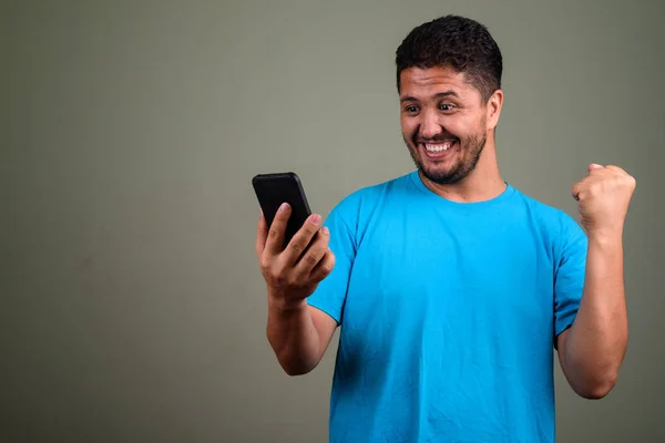 Homem barbudo persa vestindo camisa azul contra backgroun colorido — Fotografia de Stock