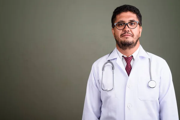 Bearded Persian man doctor against colored background — Stock Photo, Image