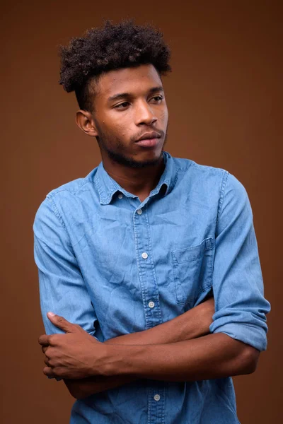 Joven hombre africano guapo pensando en fondo marrón — Foto de Stock