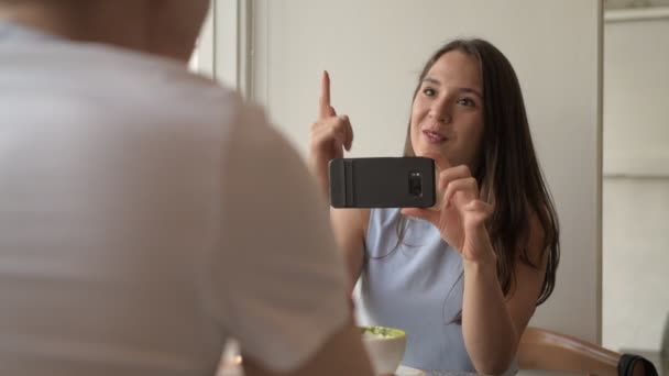 Joven mujer feliz casualmente hablando con un hombre joven en la cafetería — Vídeo de stock