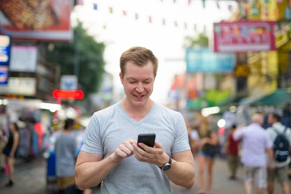 Άνθρωπος νεαρός ευτυχισμένη τουριστική χρήση τηλεφώνου κατά την άποψη του Khao San road στην Μπανγκόκ — Φωτογραφία Αρχείου