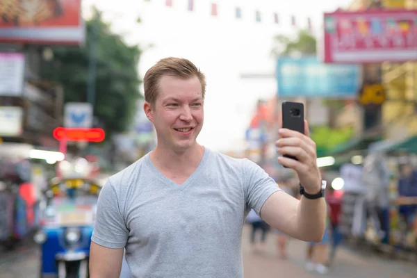 Junger glücklicher Tourist macht Selfie mit Blick auf die Khao-san-Straße in Bangkok — Stockfoto