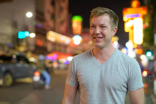 Молодий щасливі туристичних людина посміхається і мислення на вулицях Чайнатаун вночі — стокове фото
