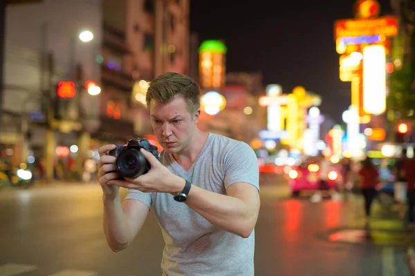 Junger Tourist fotografiert nachts mit Kamera in den Straßen von Chinatown — Stockfoto