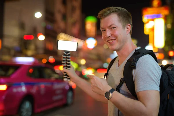 Glücklicher Tourist lächelt, während er nachts in Chinatown vlogging — Stockfoto