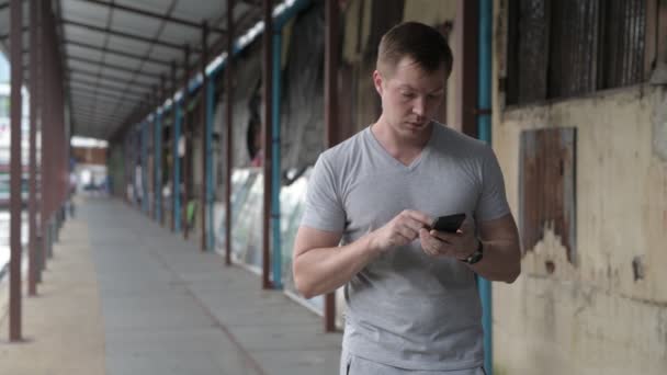 Pemuda tampan wisatawan menggunakan telepon sambil berpikir di dermaga lokal di Bangkok — Stok Video