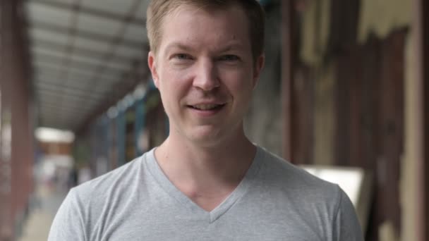 Face of young happy tourist man smiling at the local pier in Bangkok — Stock Video