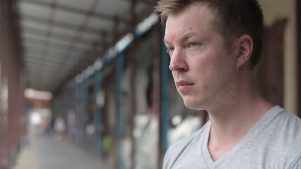 Das gesicht eines jungen touristen, der an der lokalen pier in bangkok lächelt und nachdenkt — Stockvideo