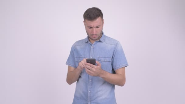Счастливый бородатый перс использует телефон на белом фоне — стоковое видео
