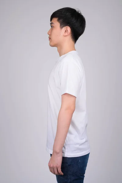 Profilo vista di giovane asiatico uomo in piedi — Foto Stock