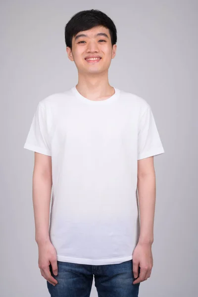 笑顔若い幸せなアジア男の立っているスタジオ撮影 — ストック写真