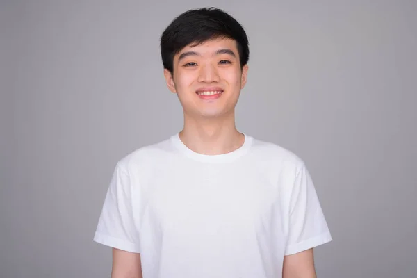 Studio záběr mladý šťastný asijský muž s úsměvem — Stock fotografie