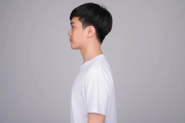 Vista del perfil de un joven asiático con camisa blanca — Foto de Stock