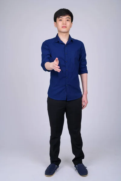 Ganzkörperaufnahme eines jungen asiatischen Geschäftsmannes beim Händedruck — Stockfoto