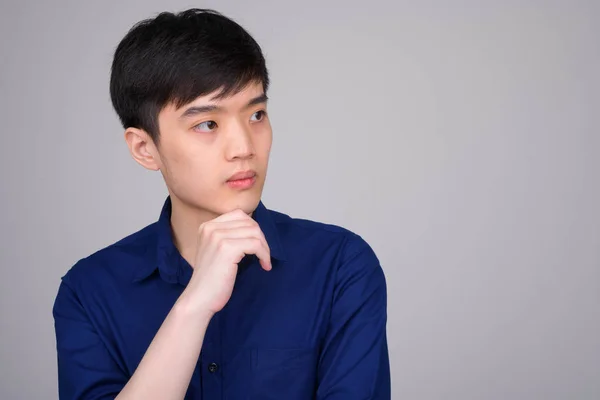 Gesicht eines jungen asiatischen Geschäftsmannes, der denkt und wegschaut — Stockfoto