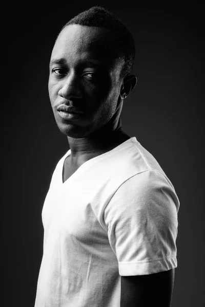 Young African man against black background in black and white
