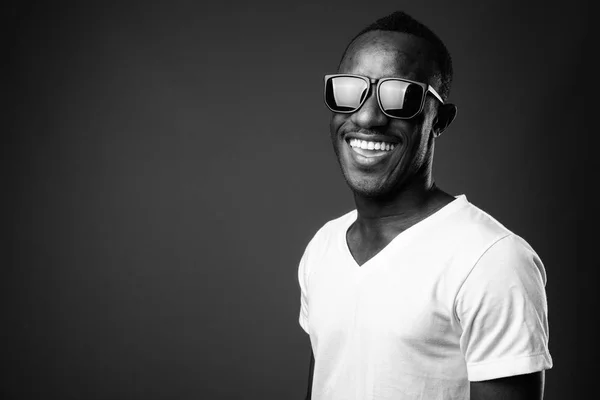 Joven africano con gafas de sol y sonriente —  Fotos de Stock