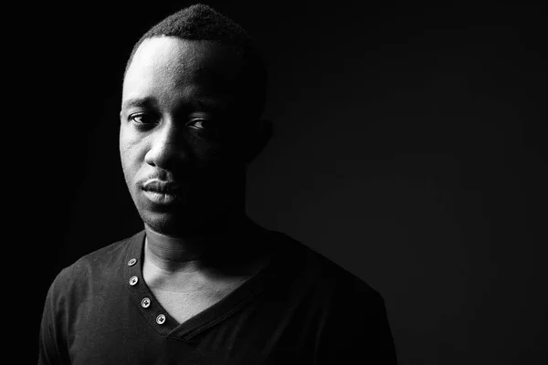 Африканських молодий чоловік проти чорний фон у чорно-білому — стокове фото