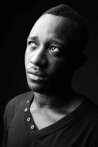 Jovem africano contra fundo preto em preto e branco — Fotografia de Stock