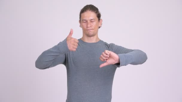 Homem confuso escolhendo entre polegares para cima e polegares para baixo — Vídeo de Stock