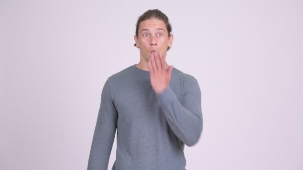 Skyldig man ser chockad samtidigt som täcker munnen mot vit bakgrund — Stockvideo