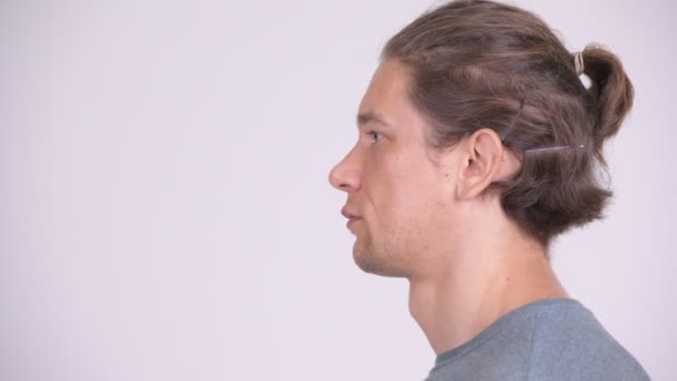 Visão de perfil de tiro na cabeça de homem bonito contra fundo branco — Vídeo de Stock
