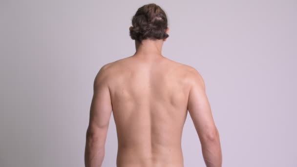 Вид сзади на мускулистого мужчину без рубашки, показывающего мышцы спины — стоковое видео