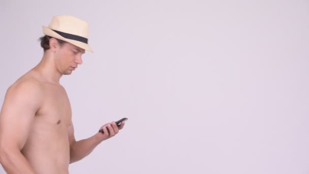Mężczyzna przystojny turysta mięśni myślenia podczas korzystania z telefonu bez koszulki — Wideo stockowe