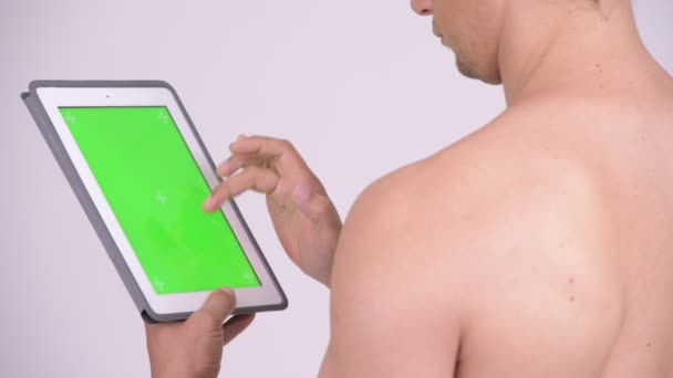 Vue arrière rapprochée de l'homme torse nu musclé utilisant une tablette numérique — Video