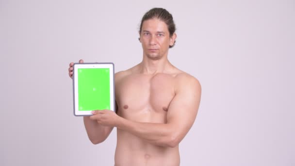 Homem sem camisa muscular feliz mostrando tablet digital — Vídeo de Stock