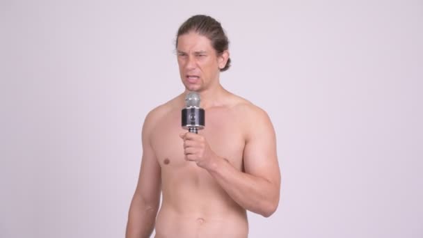 Мужчина без мускулов поет с микрофоном — стоковое видео