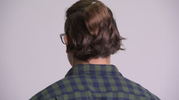 Задній знімок голови хіпстера, який дивиться назад і знімає окуляри — стокове відео