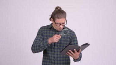 Yakışıklı hipster adam büyüteç ile kitap okuma