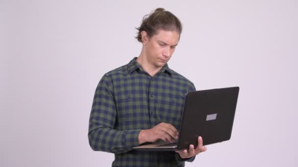 Hombre hipster guapo pensando mientras se utiliza el ordenador portátil — Vídeos de Stock