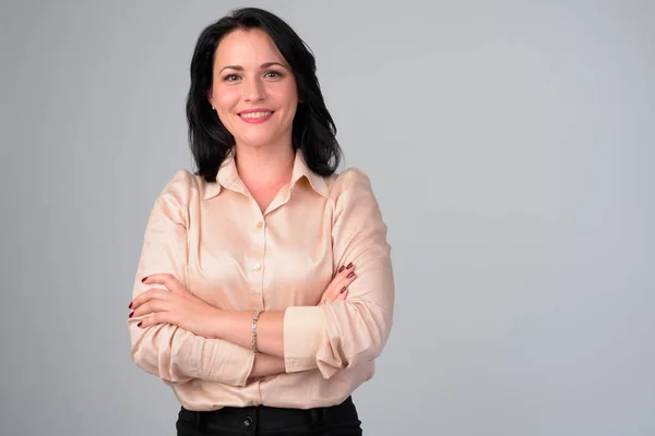 Feliz hermosa mujer de negocios sonriendo con los brazos cruzados sobre fondo blanco — Foto de Stock