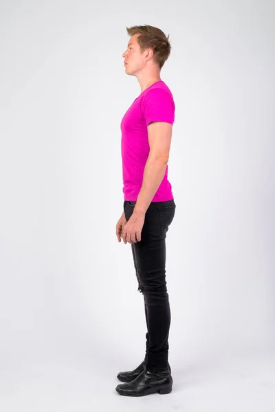 Full body shot profilo vista di giovane bell'uomo che indossa camicia viola in piedi — Foto Stock
